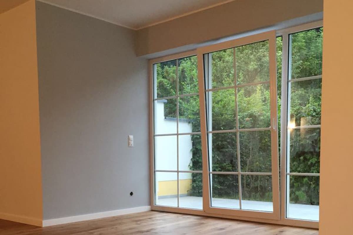 Heller Wohnraum mit Fenstertüren nach einem Malerprojekt
